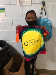 Student at MMA holding up prize (tie-dye t-shirt)